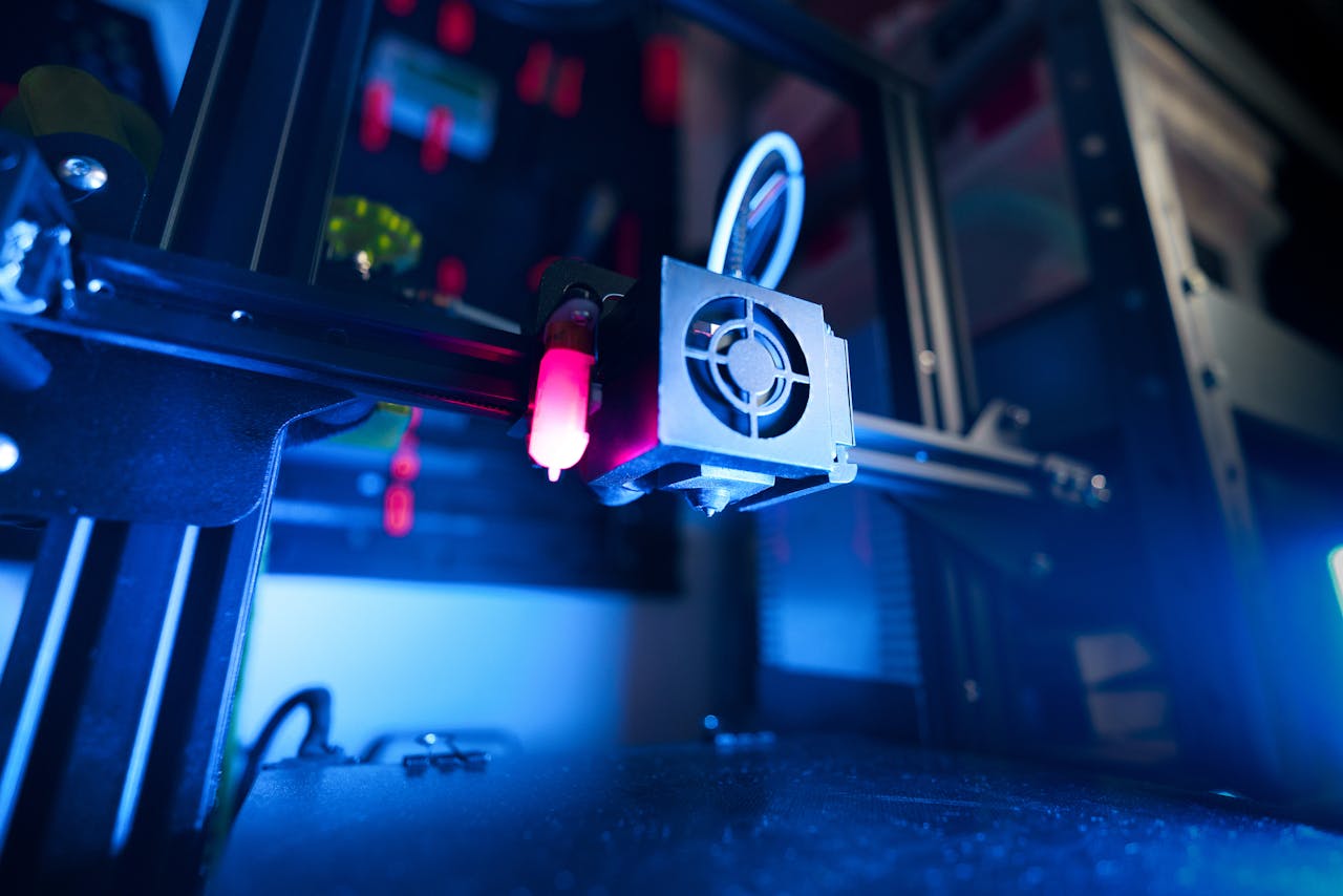 About A close-up of an illuminated 3D printer in action, highlighting modern technology.